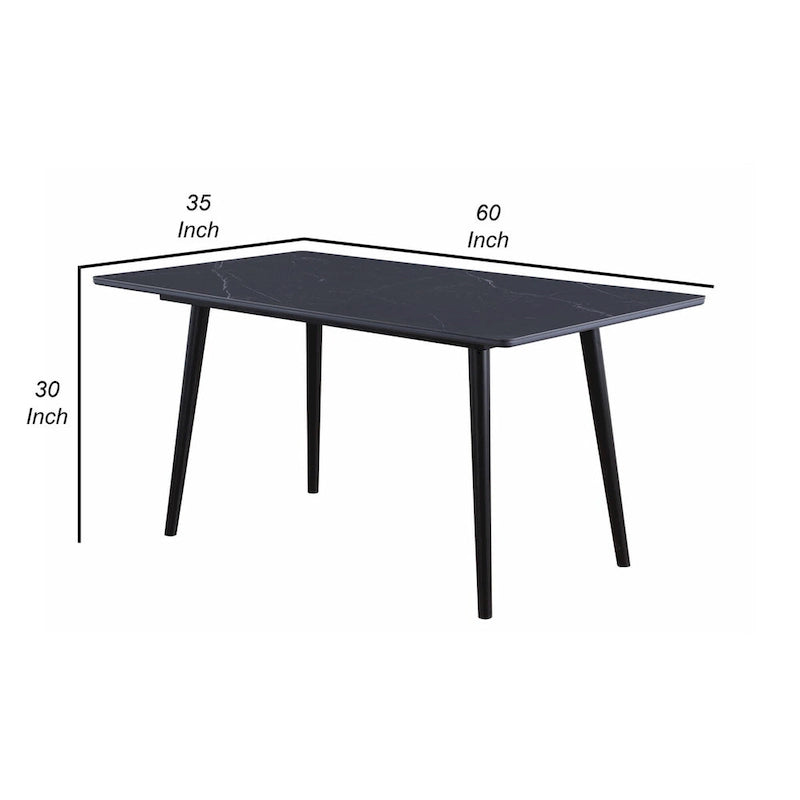 Table de salle à manger de 152 cm avec un plateau en pierre frittée noire et des pieds coniques en métal.